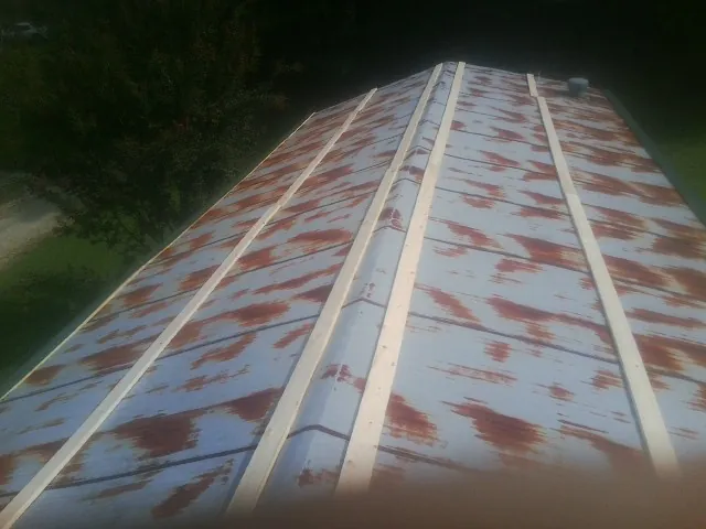 Rusted metal roof panels with new wood purlins before replacement — Storm Damage Roof Repair in Elk Park by Roofing Brothers